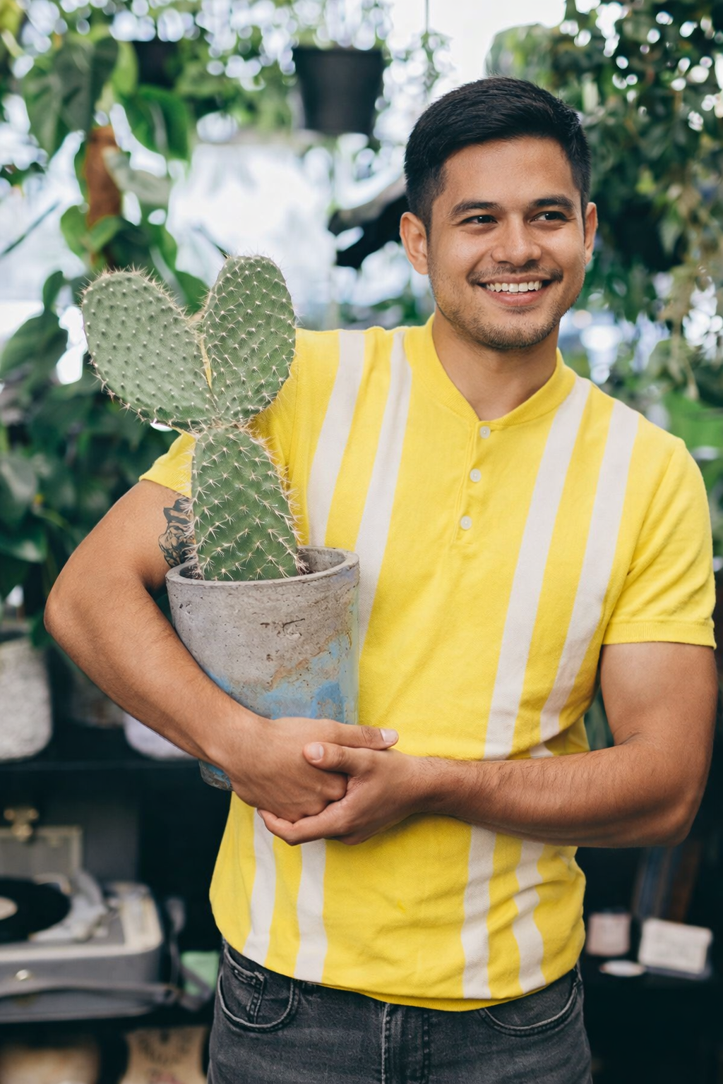man holding cactus in a cozy room